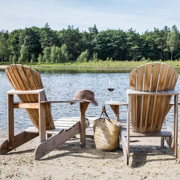 twee adirondack chairs van achteren aan het water