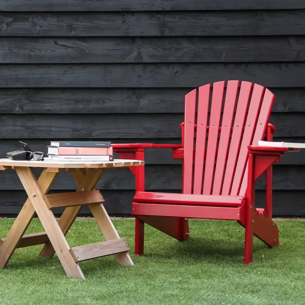 rode adirondack chair naast houten bijzettafel